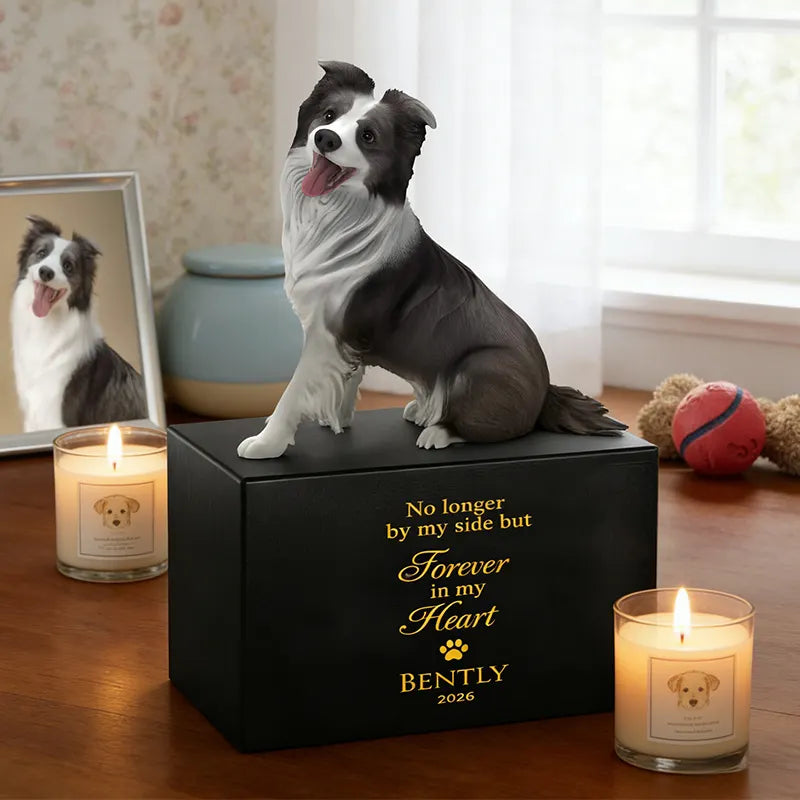 The PawPrint Dog Urn features a lifelike 3D dog sculpture, custom engraving reading, "No longer by my side but forever in my heart, Bently 2026," with two lit candles, a pet photo, and a red toy ball on the memorial table.