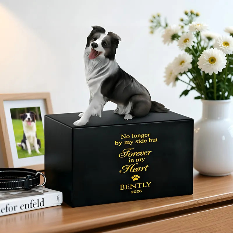 A lifelike 3D dog sculpture sits atop the PawPrint Dog Urn, engraved with "No longer by my side but forever in my heart, Bently 2026." The urn rests on a table surrounded by flowers, a leash, and a framed photo of the cherished pet.